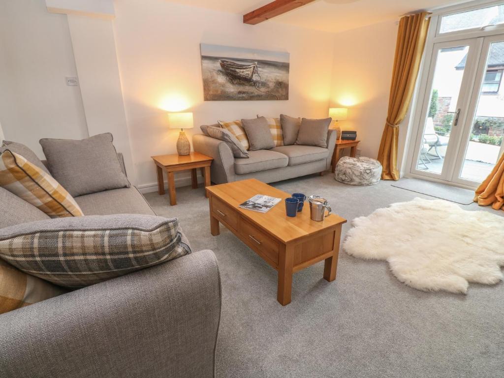 uma sala de estar com dois sofás e uma mesa de centro em Riverside Cottage em Falmouth