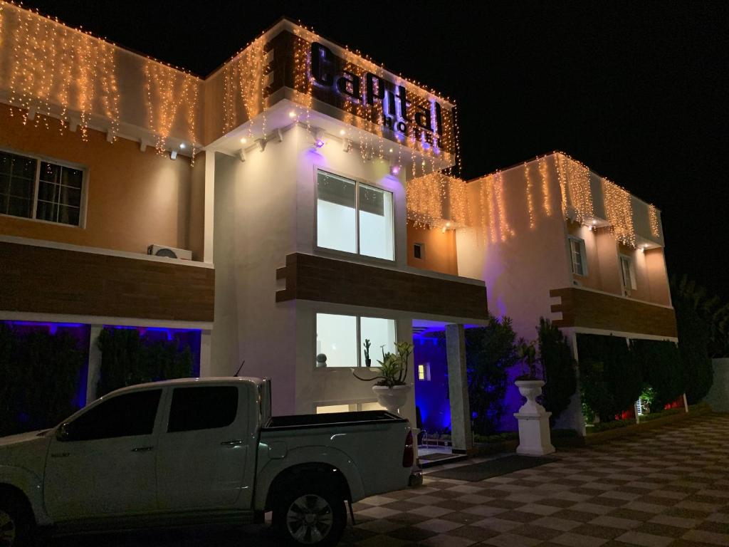 a white truck parked in front of a house with christmas lights at Capital Hôtel in Brazzaville