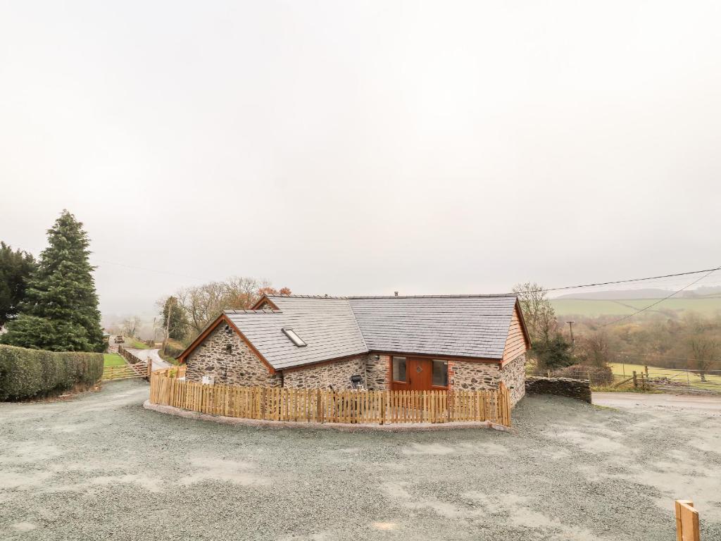 a stone house with a fence in front of it at Cut Moch, Plas Moelfre Hall Barns in Oswestry