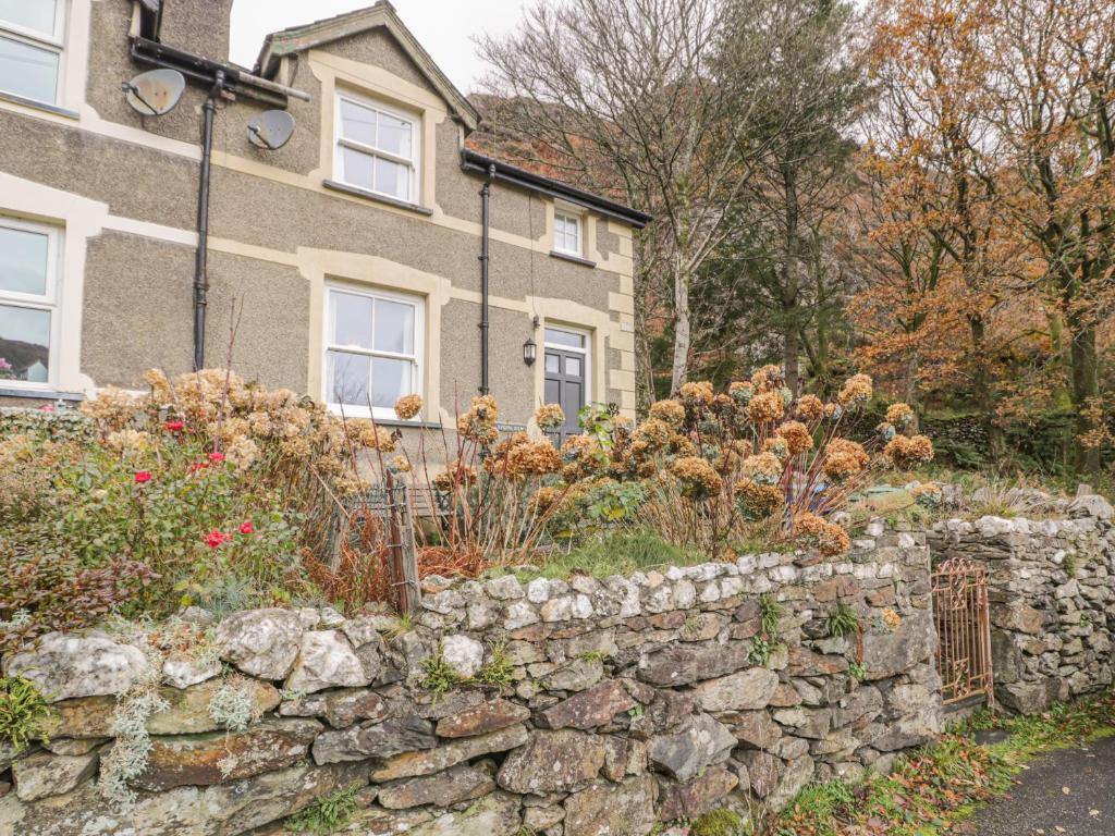 a stone retaining wall in front of a house at Sygun View in Caernarfon