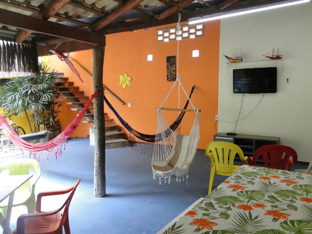 Zimmer mit Hängematte, Tisch und Stühlen in der Unterkunft Céu Azul Casa de Praia in São Sebastião