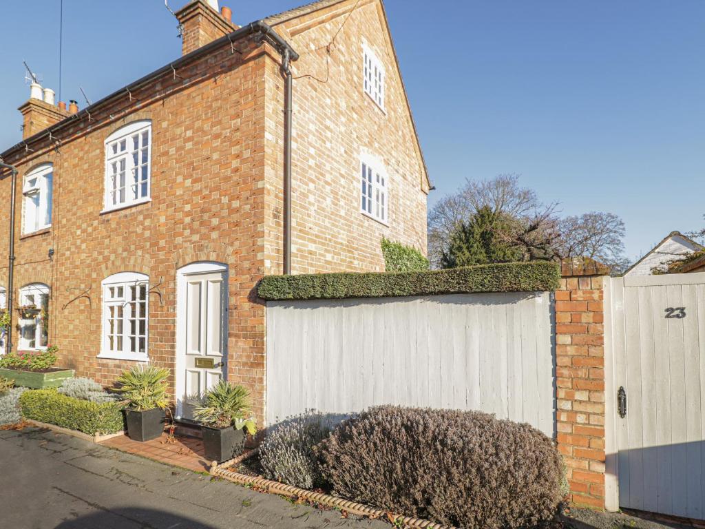 a large brick house with a white garage at 23 Clifford Chambers in Stratford-upon-Avon