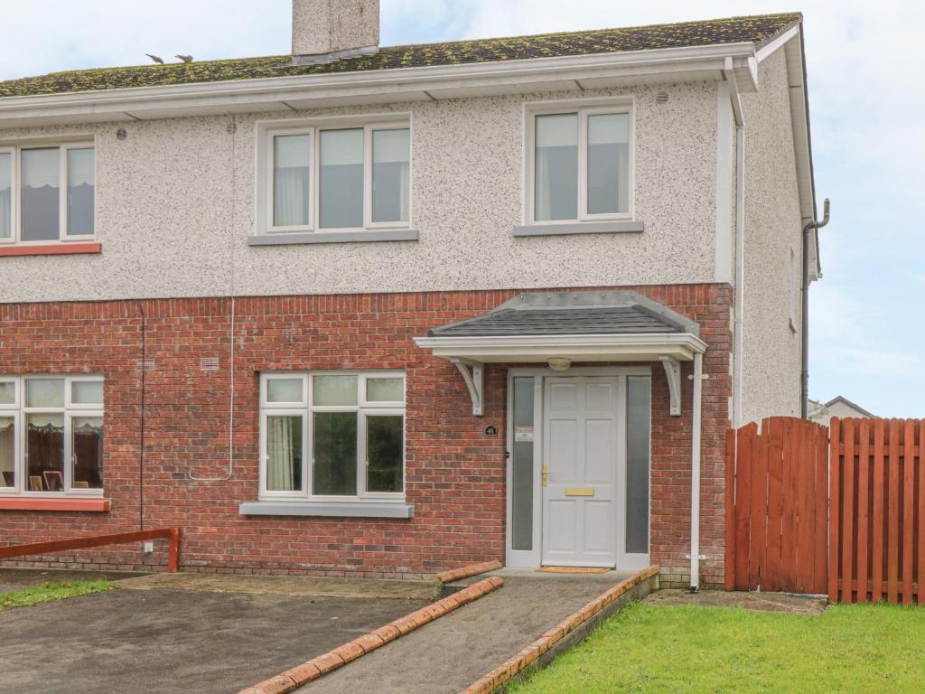 a red brick house with a white door at Duffy's Cottage in Ballymote