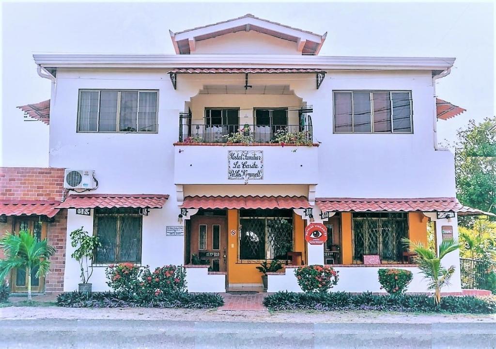 una casa blanca con puerta naranja en Hostel Kimmell / Hostal Familiar La Casita De Los Kimmell, en Las Tablas