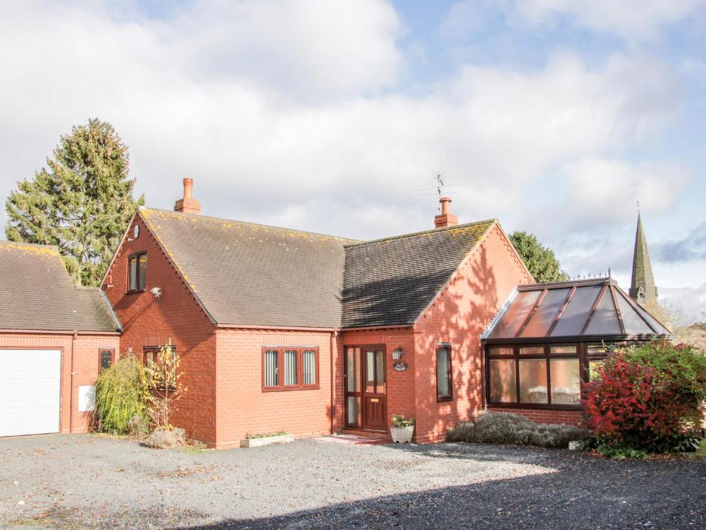 a red brick house with a garage at Court Farm in Kidderminster