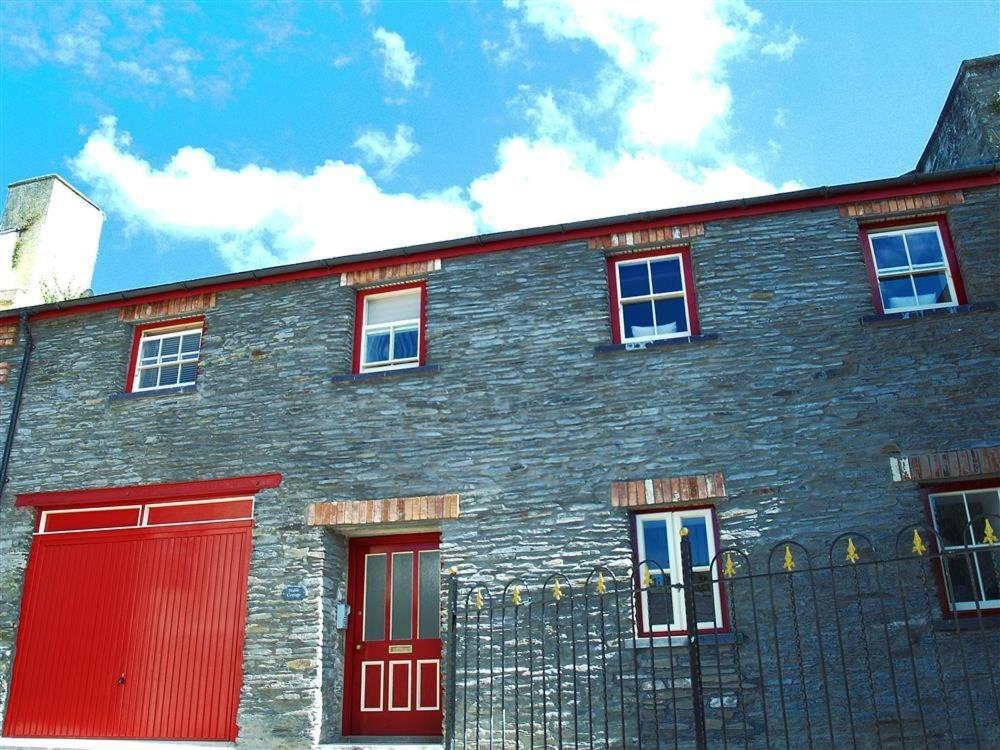 a large brick building with red doors and windows at Stable Cottage, Cardigan in Cardigan