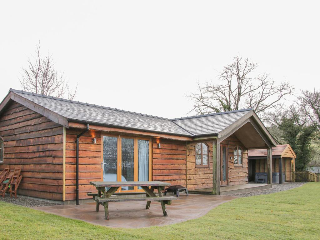 a log cabin with a picnic table in front of it at Hillside Lodge in Ludlow