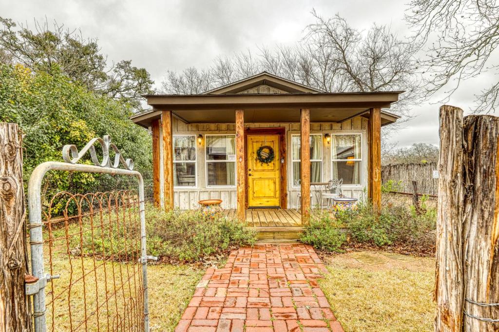 a house with a yellow door and a brick walkway at The Studio @ Durst Haus in Fredericksburg