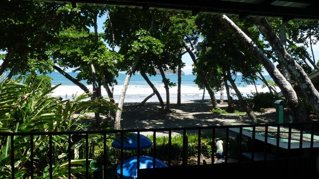 uma vista para a praia a partir da varanda de uma casa em Hotel Arboleda em Quepos