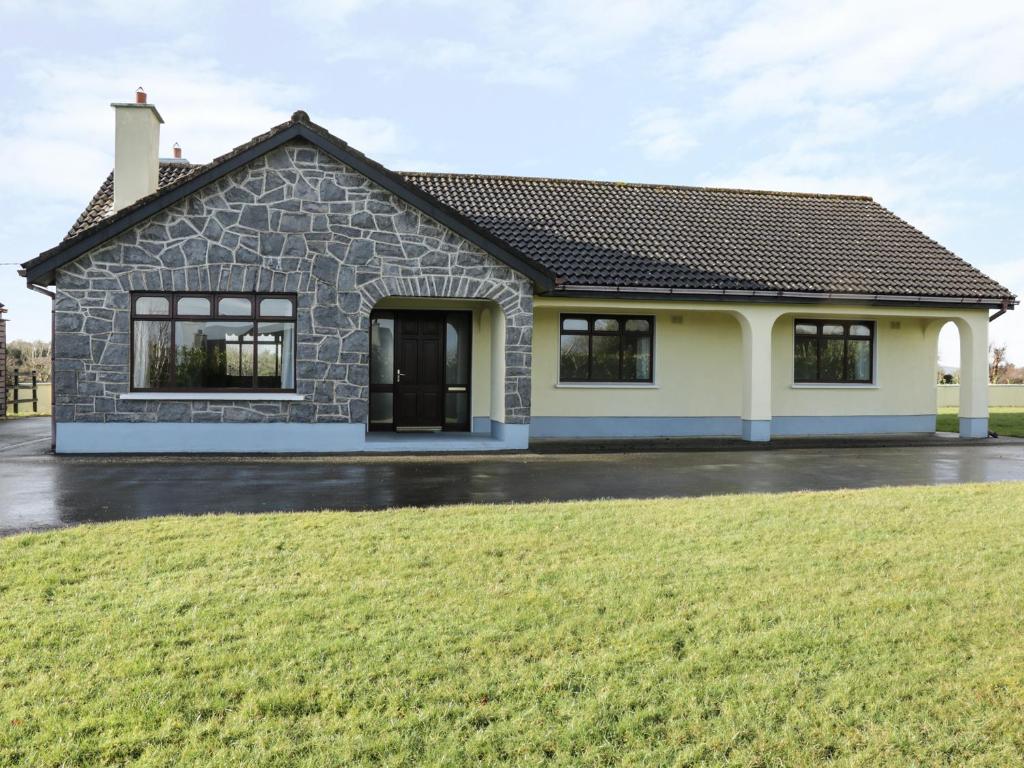 a house with a green lawn in front of it at Castle View in Oughterard