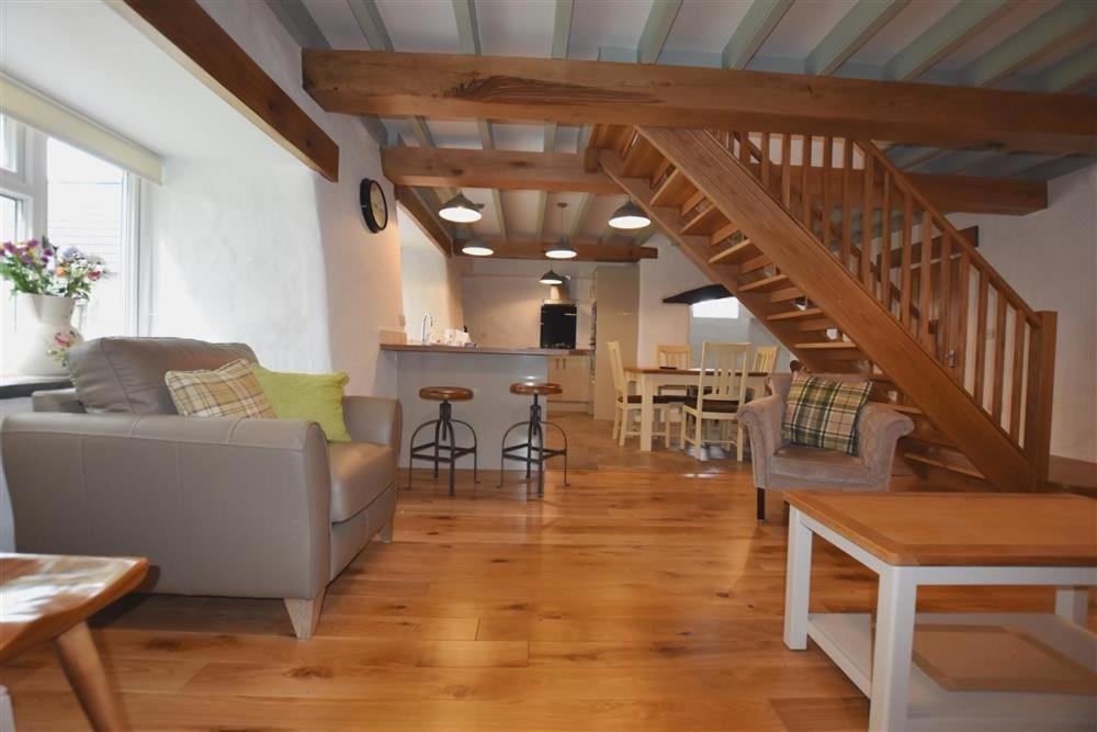 a living room with a couch and a staircase at The Old Farmhouse Kitchen in Haverfordwest