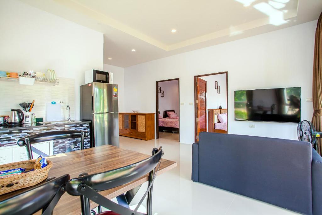 uma cozinha e sala de estar com uma mesa e um frigorífico em Rouble Villa Ao Nang em Praia de Aonang