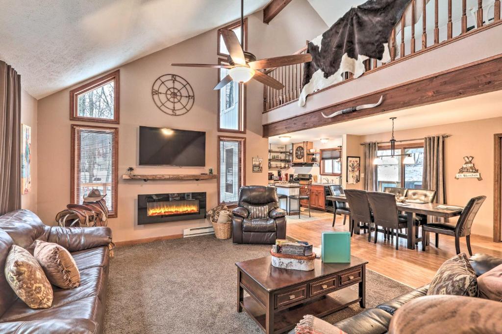 a living room with leather furniture and a fireplace at Pocono Mountains Retreat with Pool Table and Hot Tub! in Albrightsville
