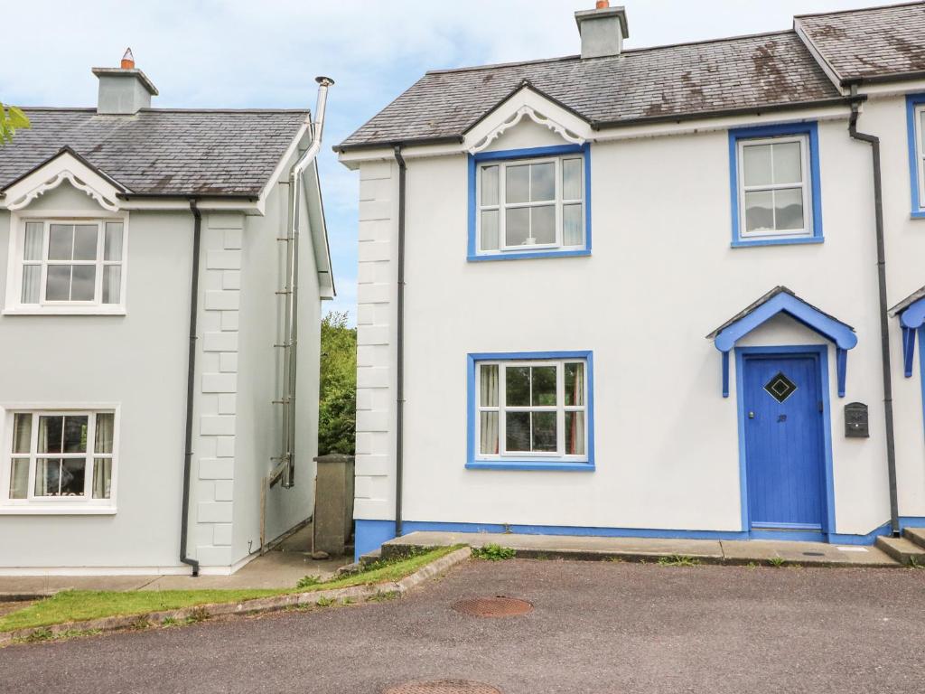 a white house with a blue door at 18 Dalewood in Glengarriff