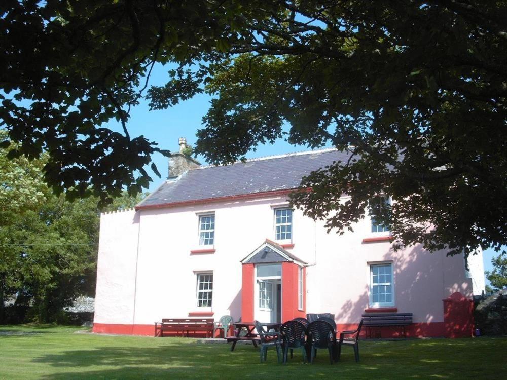 a large white building with benches in front of it at Tremynydd Fawr in St. Davids