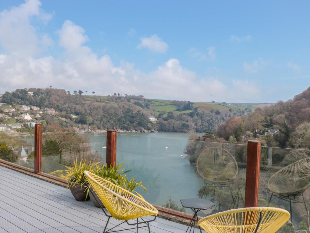 a balcony with chairs and a view of a lake at High Banks in Dartmouth