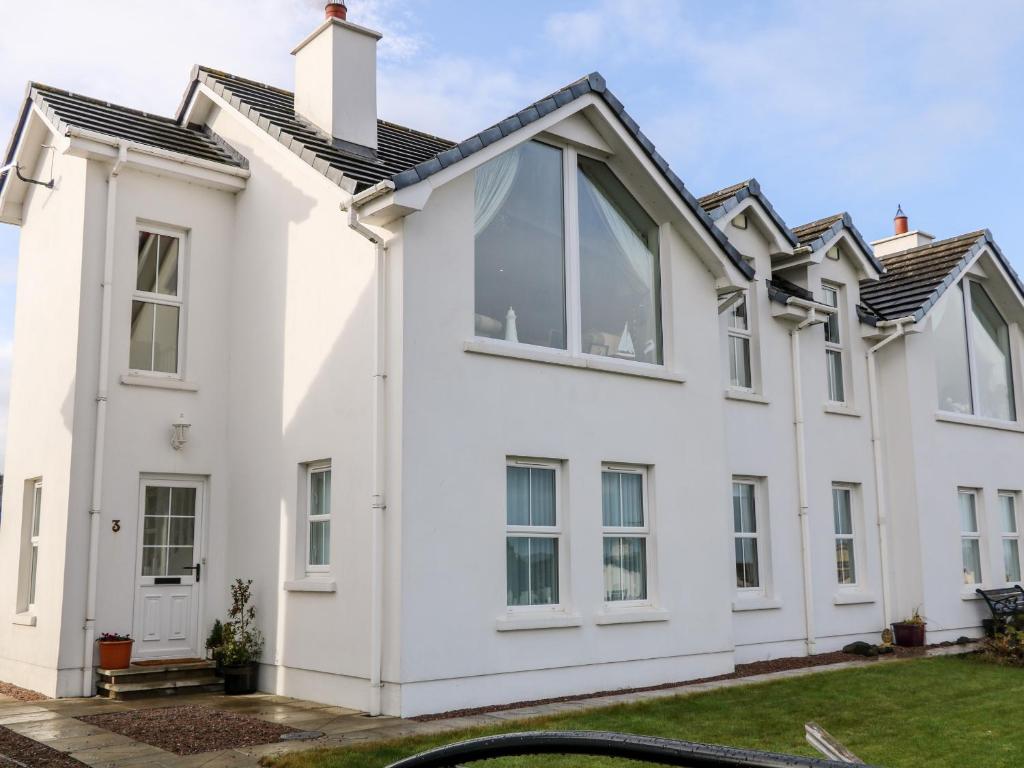 a white house with large windows at Seaview in Coleraine