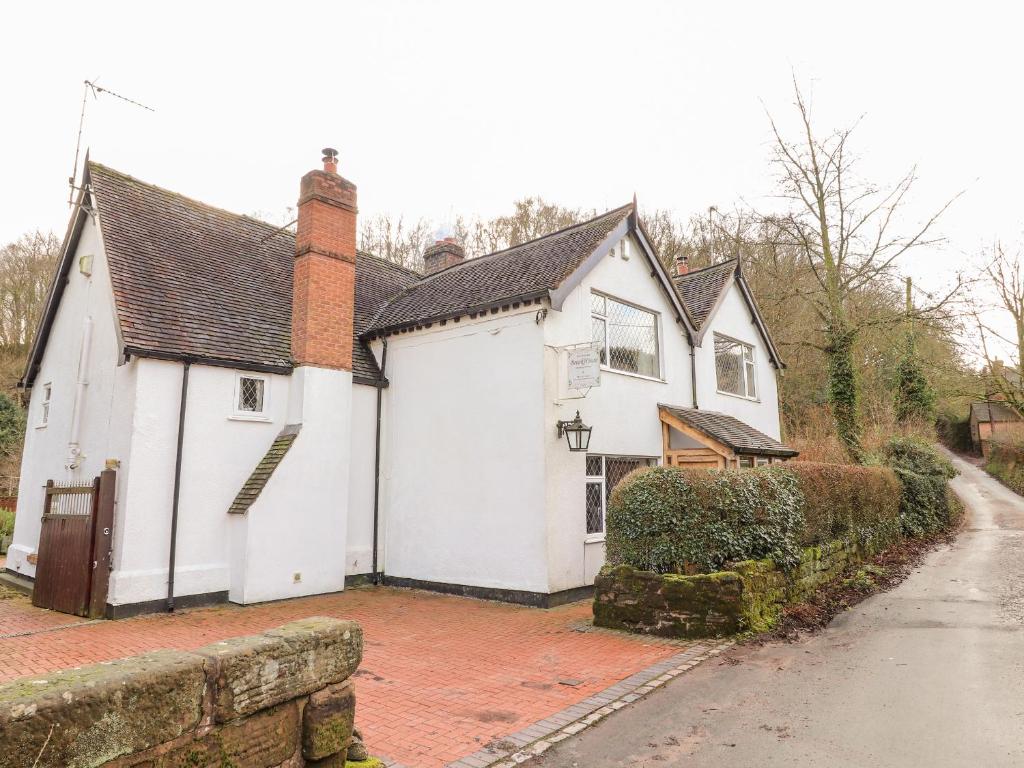 a white house with a garage on a street at Brook House in Stafford