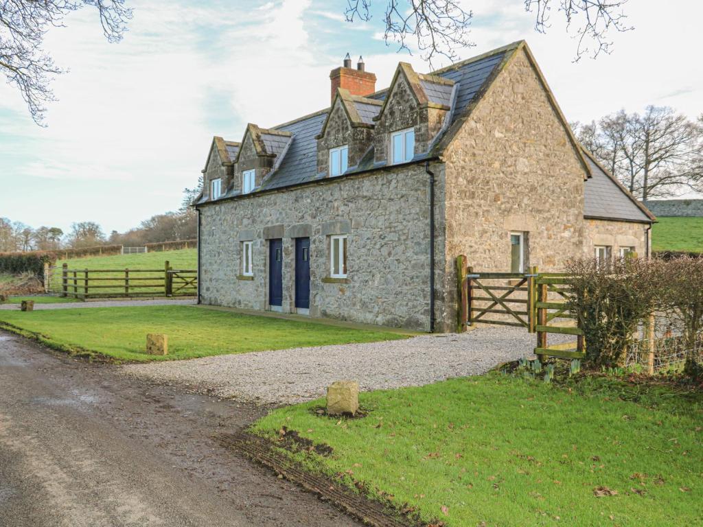 een oud stenen huis op een onverharde weg bij Goose Cottage in Caledon