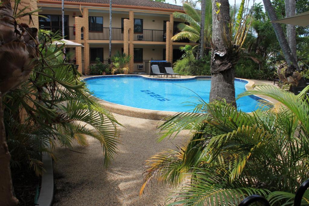 a large swimming pool in front of a hotel at Oasis Inn Apartments in Cairns