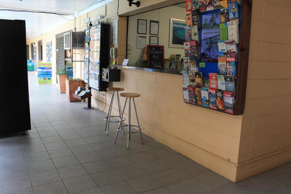a person sitting at a counter in a store at Oasis Inn Apartments in Cairns