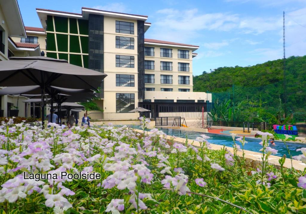 a hotel with a pool and flowers in the foreground at Fairways and Bluewater Boracay in Boracay