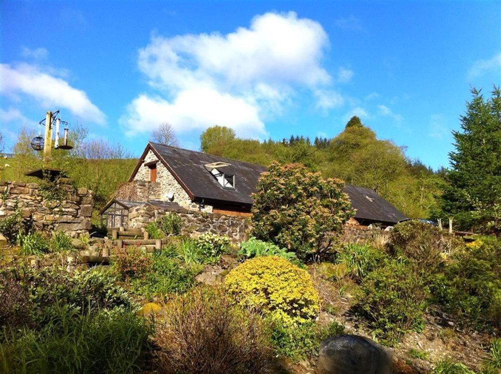 a house on a hill with a garden at Upper Barn Cottage in Aberangell