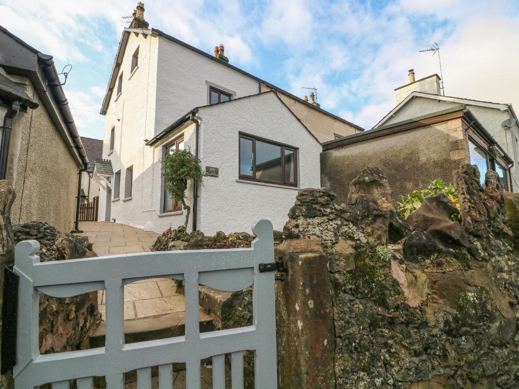 een wit hek voor een wit huis bij Rose Cottage in Grange Over Sands