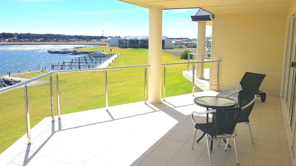 a balcony with a table and chairs and a view of the water at Island Waterfront Getaway - WiFi in Hindmarsh Island