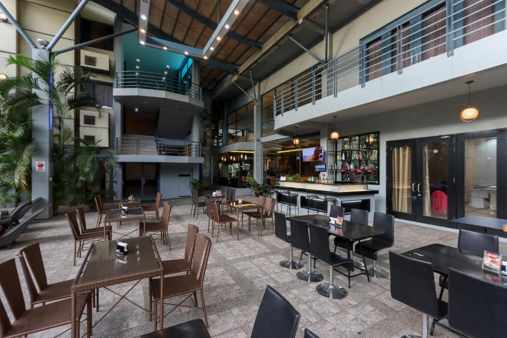 un ristorante con tavoli e sedie e un bar di Technopark Hotel a Santa Rosa