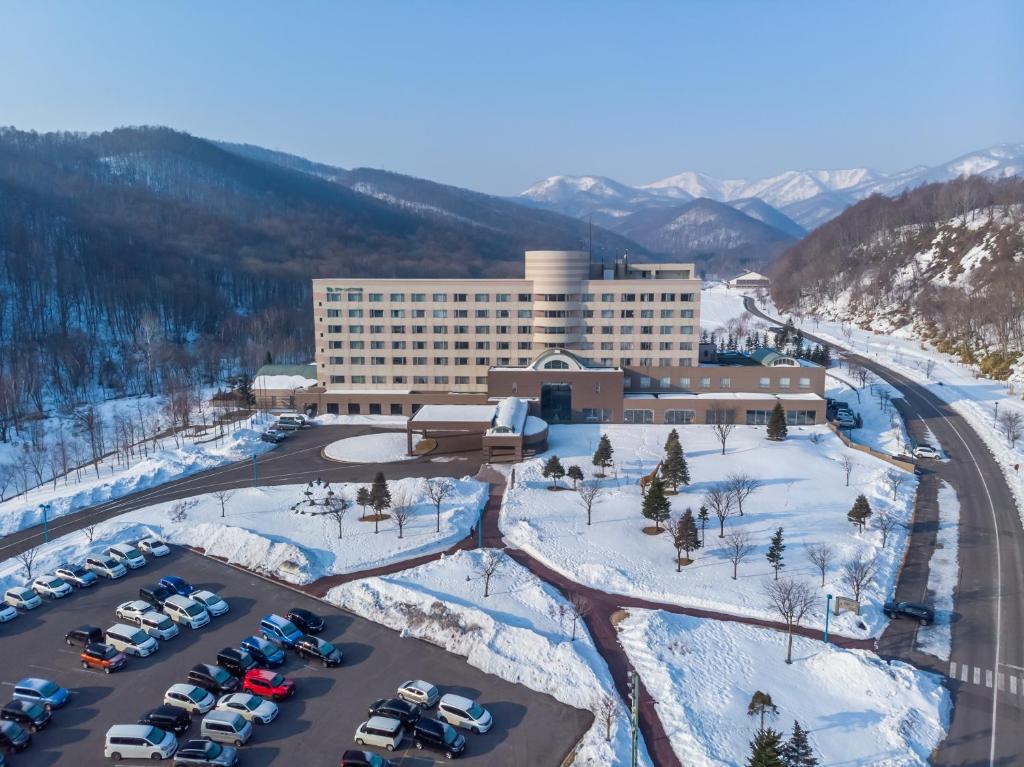 een luchtzicht op een hotel met auto's geparkeerd op een parkeerplaats bij LiVEMAX RESORT Hakodate Greenpia Onuma in Mori