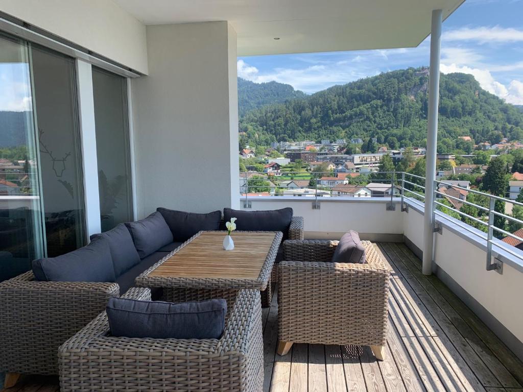 einen Balkon mit einem Sofa, einem Tisch und Stühlen in der Unterkunft Luxus Penthouse Bregenz Feldmoos mit Whirlpool & riesen Terrasse, nahe Festspiele in Bregenz