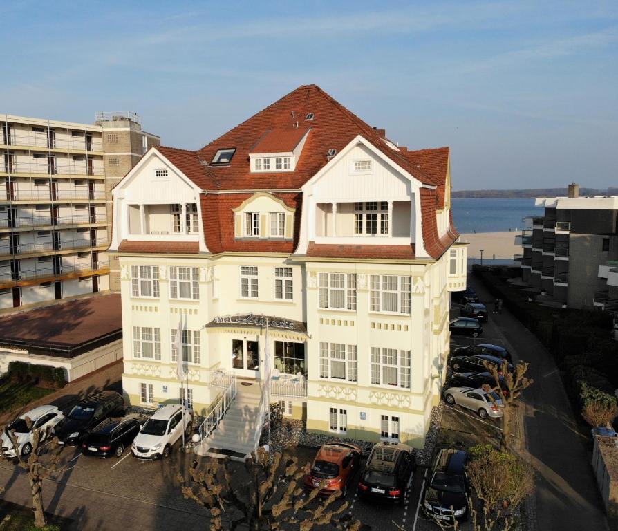 a large white building with a red roof at Hotel Atlantic Travemünde in Travemünde