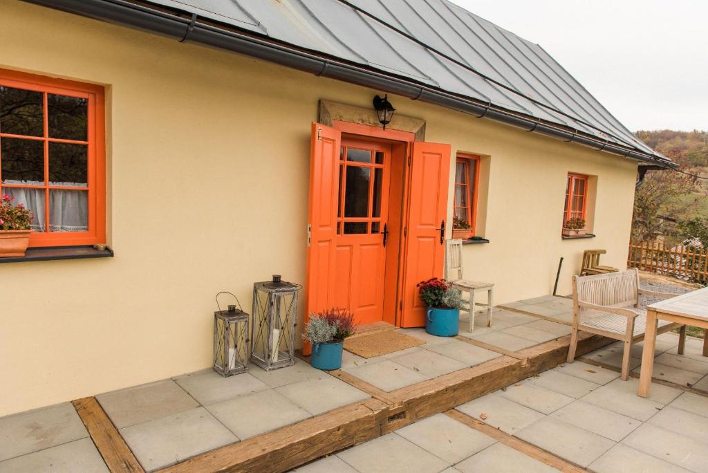 an orange door on a house with a patio at Nebo nad Štiavnicou - oranžová chalupa na okraji lesa in Banská Štiavnica