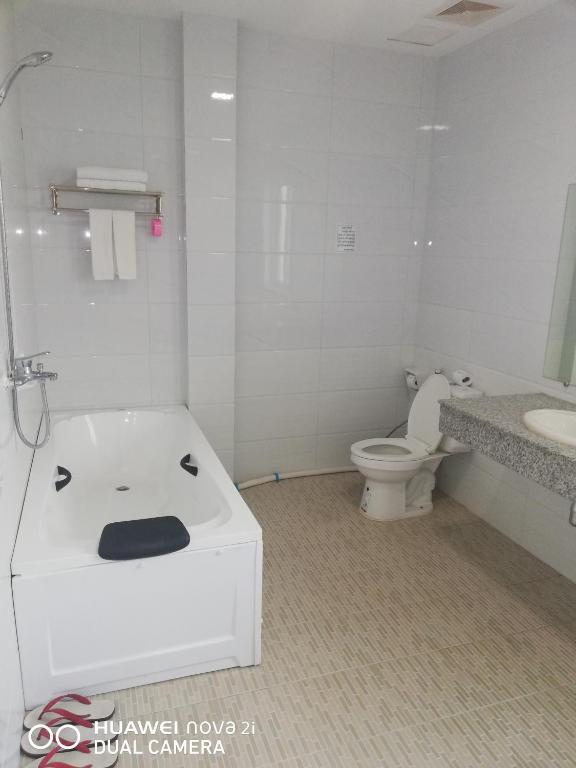 un bagno con vasca, WC e lavandino di Supreme Hotel Yangon a Yangon