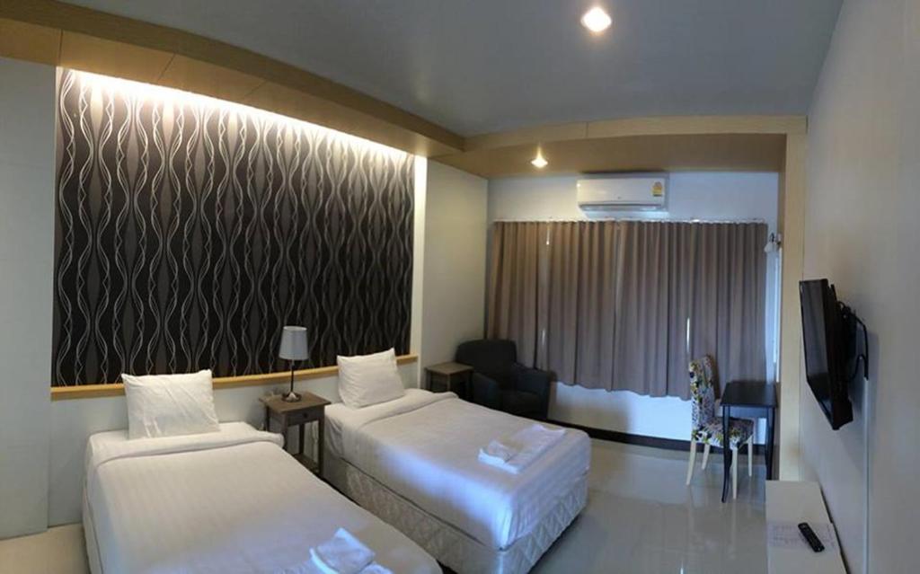 um quarto de hotel com duas camas e uma televisão em Chaisaeng in the park em Ban Tha Ngam