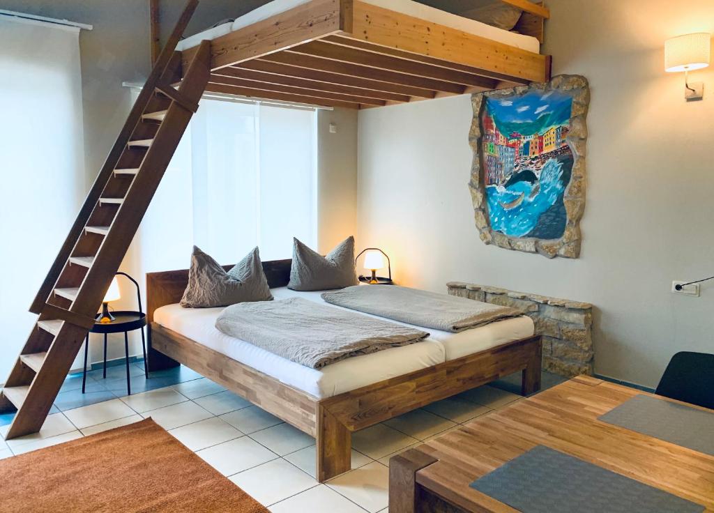 a bedroom with a loft bed with a ladder at Hotel-Bistro-Europa in Merchweiler