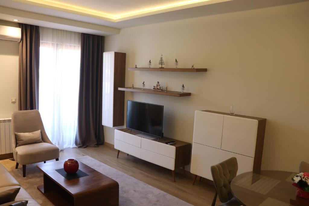 a living room with a flat screen tv and a couch at Hotel Villa Gracia in Budva