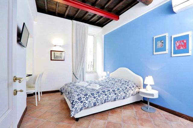 1 dormitorio con paredes azules y 1 cama en una habitación en RELAIS CAVOUR 133 en Roma