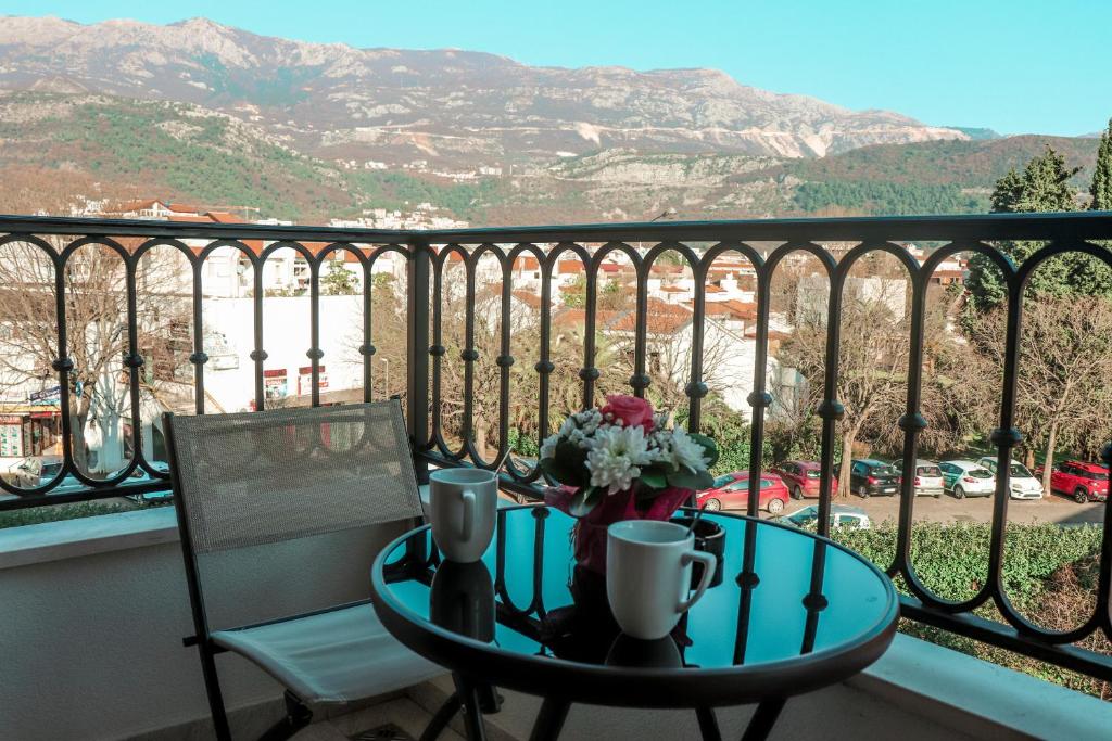 a table and a chair on a balcony with a view at Hotel Villa Gracia in Budva