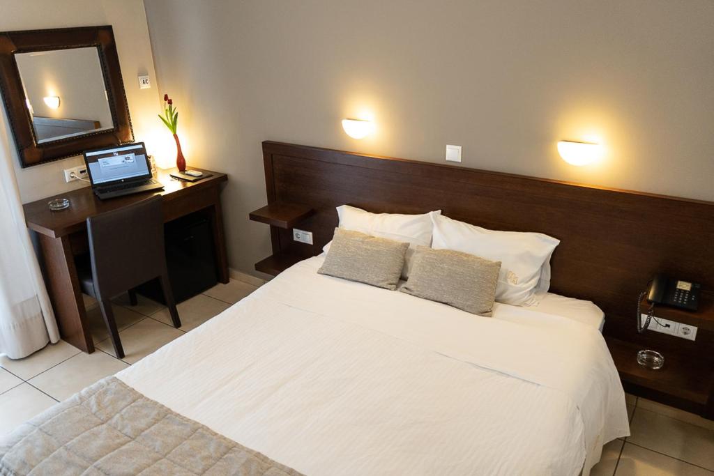 sypialnia z dużym białym łóżkiem i lustrem w obiekcie HOTEL HILL w Atenach