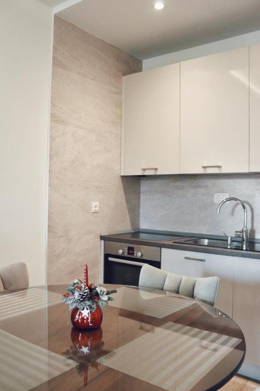 a kitchen with a dining table and a kitchen with white cabinets at Hotel Villa Gracia in Budva