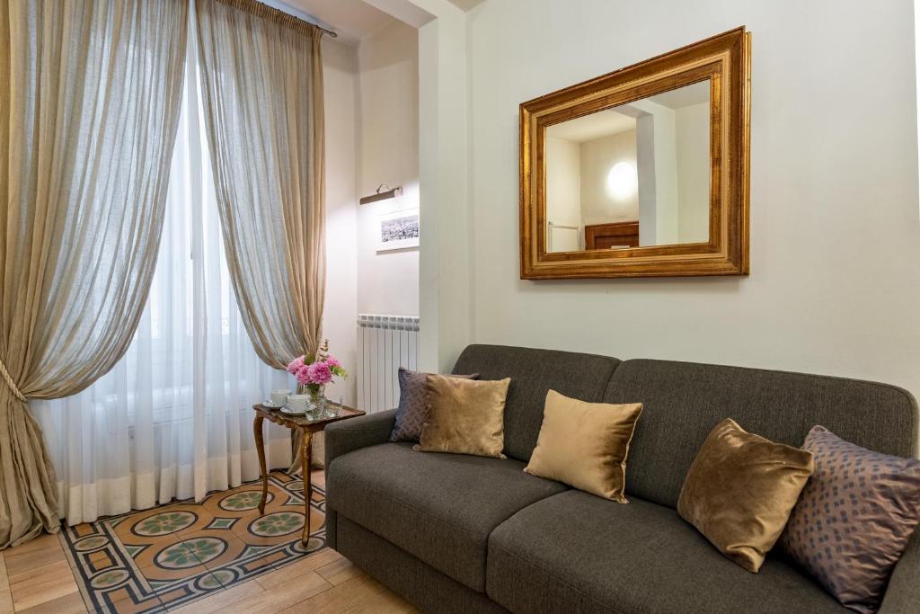 uma sala de estar com um sofá e um espelho em Windows On Florence em Florença
