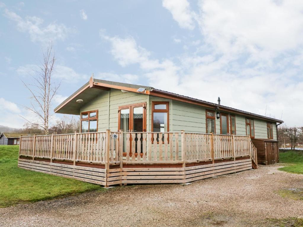 a small green house with a large porch at 16 Sherwood Lodge in Carnforth