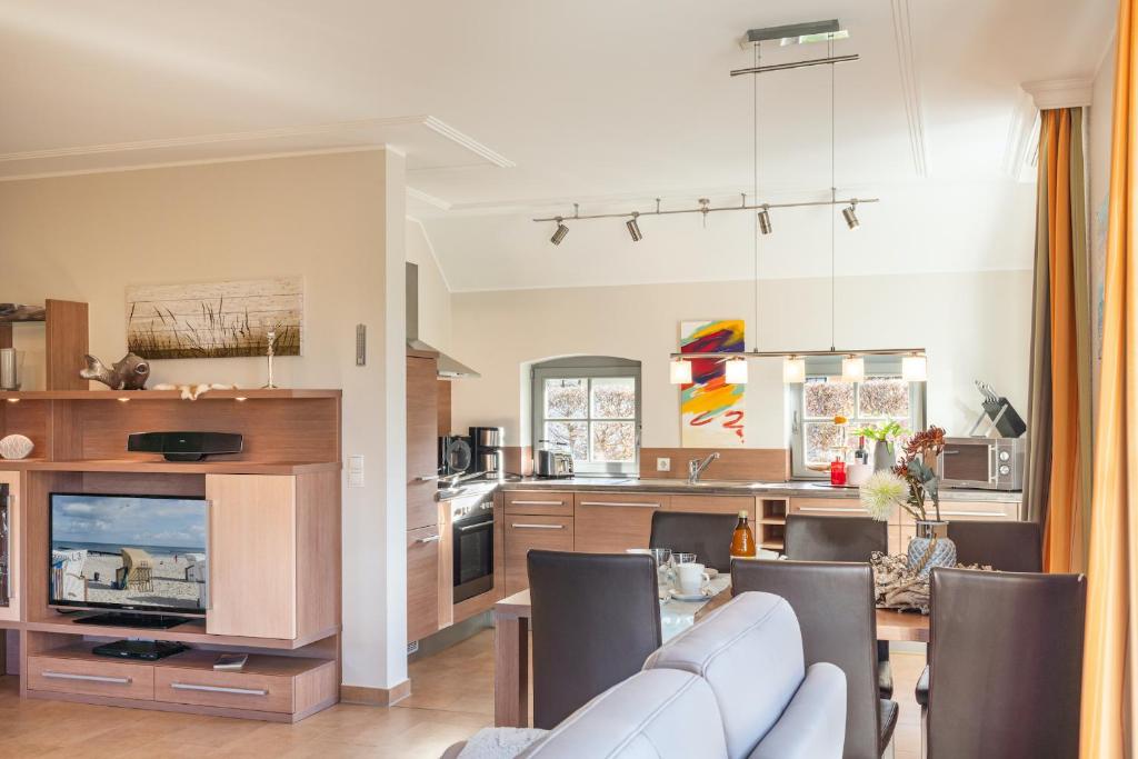 TV a/nebo společenská místnost v ubytování Ferienhaus Strandgut - Reetdachhaus in Strandnähe