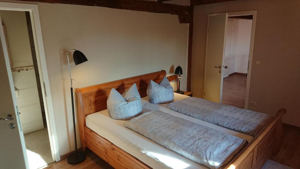 a bedroom with a bed with two blue pillows at Pension Müllers Mühle in Großenhain
