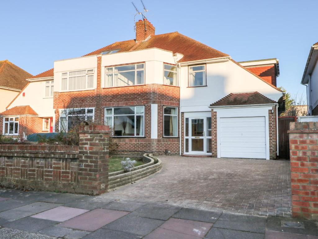 a large brick house with a white garage at Sea Dreams in Worthing