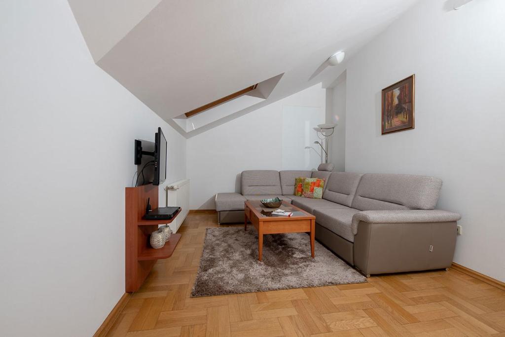 Apartmani Špoljar في زوبانيا: غرفة معيشة مع أريكة وطاولة