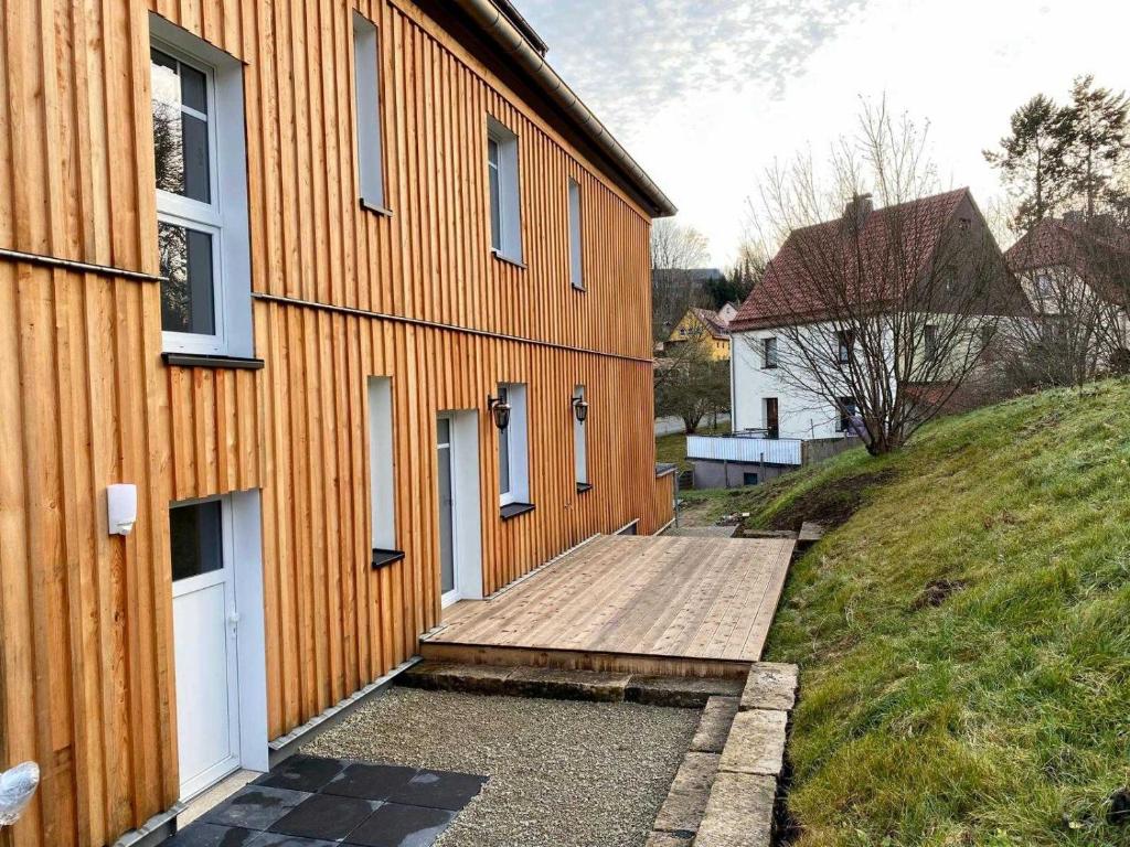 ein Gebäude mit einer hölzernen Rampe neben einem Haus in der Unterkunft FeWoWa - FerienWohnungen Walter in Bad Sachsa