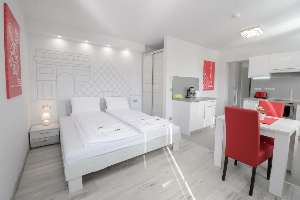 sypialnia z łóżkiem, biurkiem i czerwonym krzesłem w obiekcie HR Apartmanház w Egerze